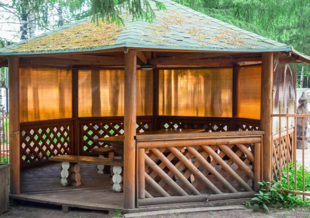 Cenador de madera con celosía y cubierta en el jardín de un chalet de Boecillo