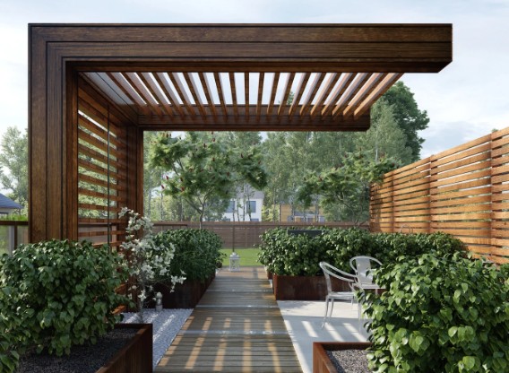 Pérgola de estructura oscura con cubierta de lamas y celosía lateral en un jardín