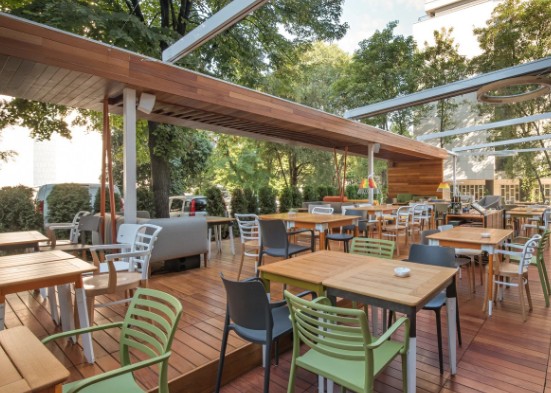 Terraza exterior cubierta con estructura de madera y lona corredera