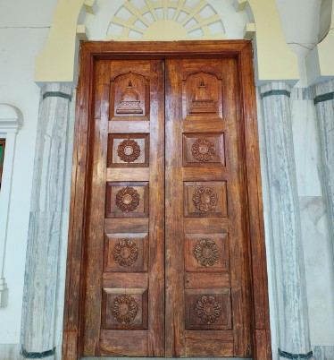 Puerta de madera maciza tallada restaurada en un portal de Valladolid